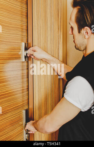 Man locking door of his home. Protection against burglary concept. Stock Photo