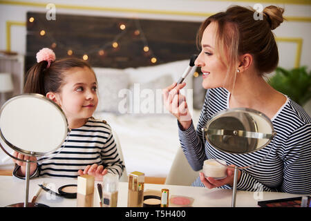 Mother and daughter applying make up together Stock Photo