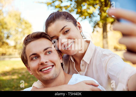 Young couple taking a selfie at a park Stock Photo