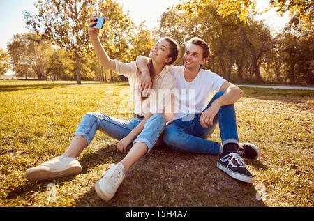 Young couple taking a selfie at a park Stock Photo