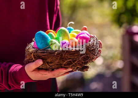 Girl holding Easter nest with colorful Easter eggs Stock Photo