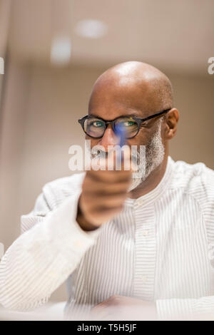 Portrait of smiling businessman pointing with pen on viewer Stock Photo