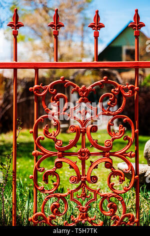 Reddish colored intricate wrought iron gate & fence Stock Photo