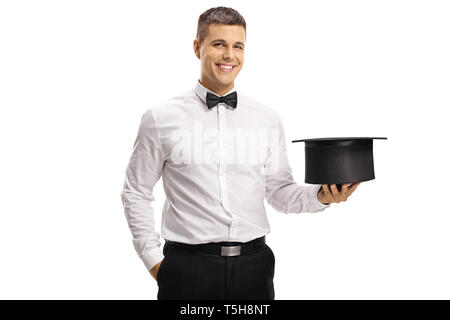 Cheerful magician holding an empty hat and smiling at the camera isolated on white background Stock Photo