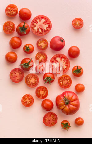 Various sized tomatoes on a pink background Stock Photo