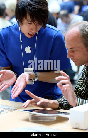 Staff giving advice on using the iPad at Apples Covent Garden store in London. 7 August 2010. Stock Photo