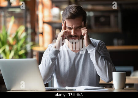 Man touching with fingers forehead thinking or suffering from headache Stock Photo