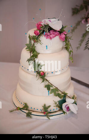 Wedding cake, three tiered wedding cake decorated with beautiful pink and white flowers decorating the tiers. Stock Photo