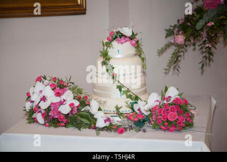 Wedding cake, three tiered wedding cake decorated with beautiful pink and white flowers decorating the tiers. Stock Photo