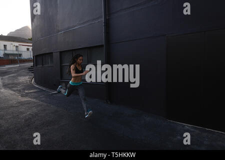 Young woman running on the street in the city Stock Photo