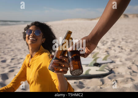 Couple toasting beer bottle at beach Stock Photo