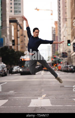 Handsome man jumping and dancing on street Stock Photo