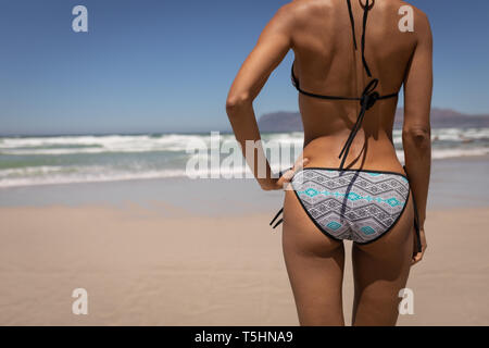 Woman in bikini standing on the beach Stock Photo