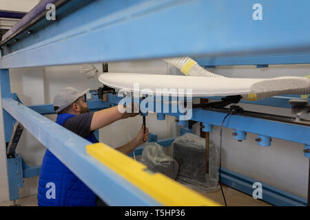 Man making a surfboard in workshop Stock Photo