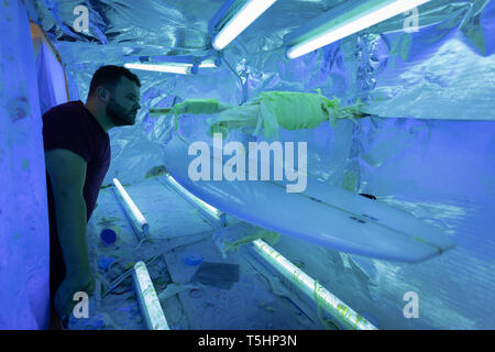 Man making a surfboard in workshop Stock Photo