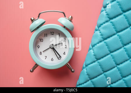 Blue analog metal alarm clock on stylish blue-pink background. The concept of time in pastel colors Stock Photo