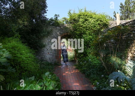 a young woman standing inside a brick arch in the Kipling gardens, Rottingdean, Brighton, UK Stock Photo