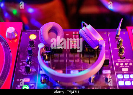 Headphones on illuminated mixing board Stock Photo