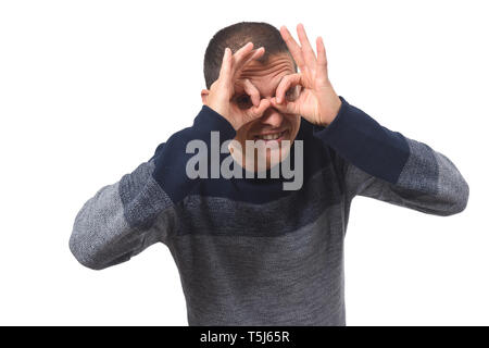 man looking through fingers as if wearing glasses on white background Stock Photo