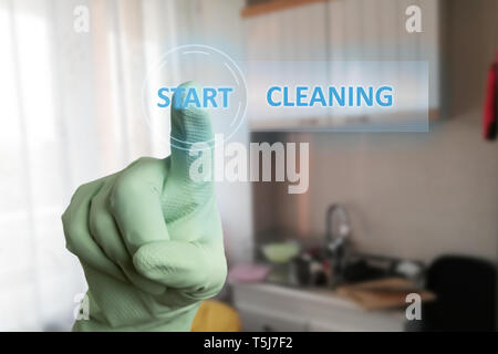 Person wearing green latex glove touching start cleaning text button on invisible screen with index finger Stock Photo