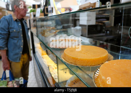 Customer looking at Toucinho do Ceu lard cake pastry stall inside Mercado Bom Sucesso Portuguese food & produce market Porto Portugal EU KATHY DEWITT Stock Photo