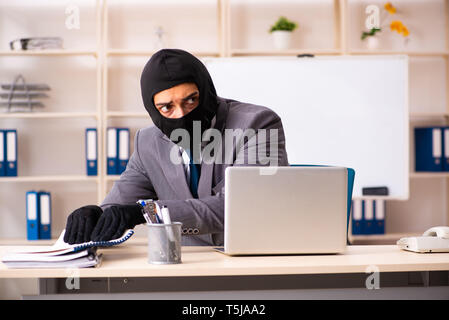 Male gangster stealing information from the office Stock Photo
