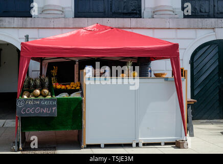 Kiosk with red tented roof next to Revolution London on Buccleuch Passage,selling fresh coconut and other foods. Richmond, London. May, 2018 Stock Photo