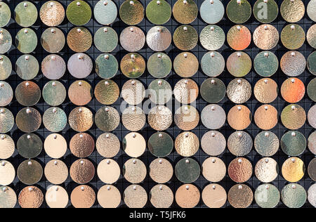 Background from small round metal plates of golden color. Golden background of round gold discs chaotically rotating in wind Stock Photo