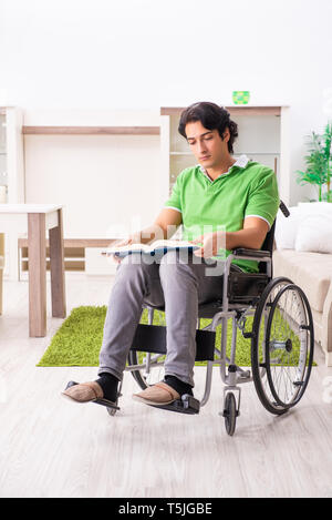 Young handsome man in wheelchair at home Stock Photo