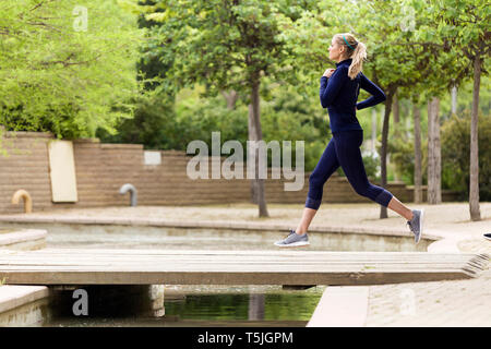 Sporty woman running in a park Stock Photo
