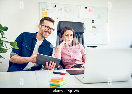Two colleagues working together at desk in office Stock Photo