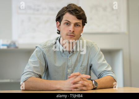 Portrait of businessman sitting at desk in office Stock Photo