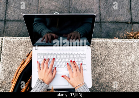 Close-up of woman using laptop outdoors Stock Photo
