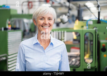 Portrait of smiling senior businesswoman in a factory Stock Photo
