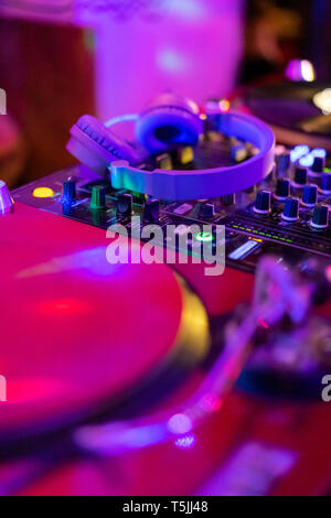 Headphones on illuminated mixing board Stock Photo