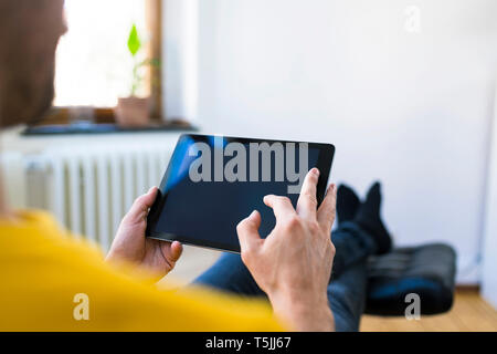 Close-up of man using tablet at home Stock Photo