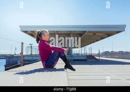 Sportive mature woman during stretching Stock Photo