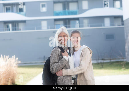 Portrait of smiling mother and adult daughter outdoors Stock Photo