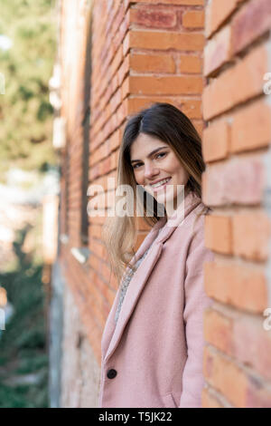 Portrait of a happy young woman at a brick building Stock Photo - Alamy