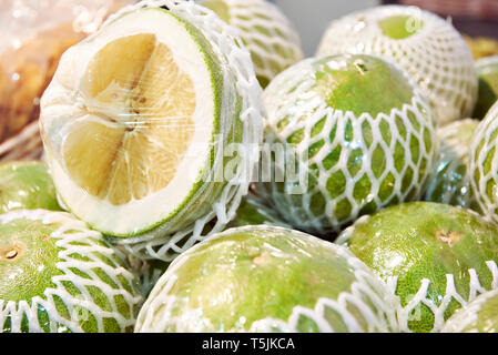 Pomelo fruits in the packaging on the market counter Stock Photo