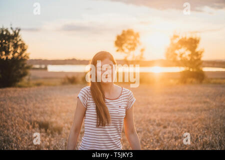 Portrait of young woman relaxing in nature at sunset Stock Photo