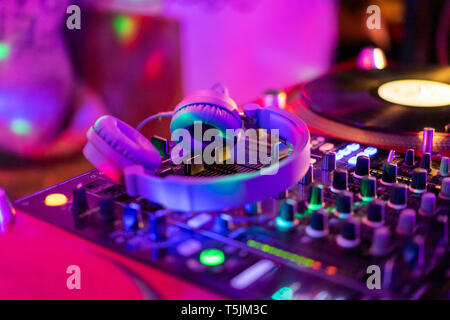 Headphones on illuminated mixing board Stock Photo