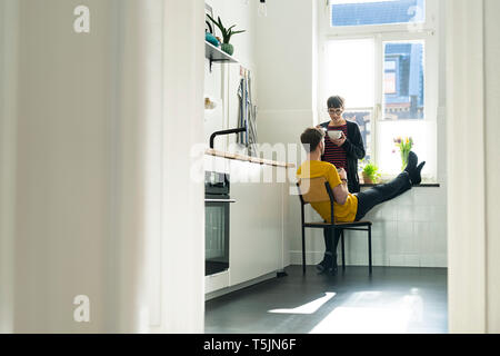 Couple at the window in kitchen at home Stock Photo