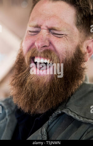 Portrait of laughing bearded man with light brown hair. Stock Photo