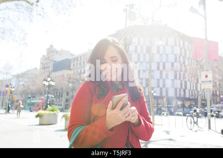 Woman using cell phone in the city Stock Photo