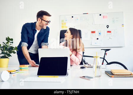 Two colleagues working together on laptop in office Stock Photo