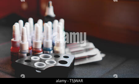 Many professional bottles with colored ink for tattoos - black background Stock Photo