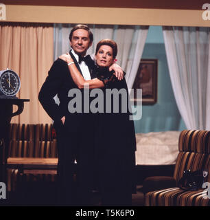 Der Schauspieler, Entertainer und Synchronsprecher Harald Juhnke posiert mit seiner Frau Chariklia Baxevanos in einem Wohnzimmer oder an einem Set, Deutschland 1970er. The actor, entertainer and voice actor Harald Juhnke poses with his wife Chariklia Baxevanos in a living room or on a set, Germany 1970s. Stock Photo