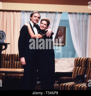 Der Schauspieler, Entertainer und Synchronsprecher Harald Juhnke posiert mit seiner Frau Chariklia Baxevanos in einem Wohnzimmer oder an einem Set, Deutschland 1970er. The actor, entertainer and voice actor Harald Juhnke poses with his wife Chariklia Baxevanos in a living room or on a set, Germany 1970s. Stock Photo