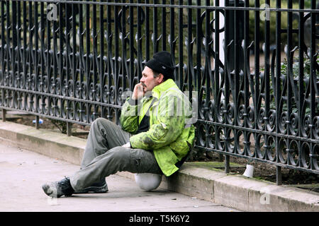 A pensive looking construction worker sitting on his hat having a break from work. London. 03.02.2010. Stock Photo